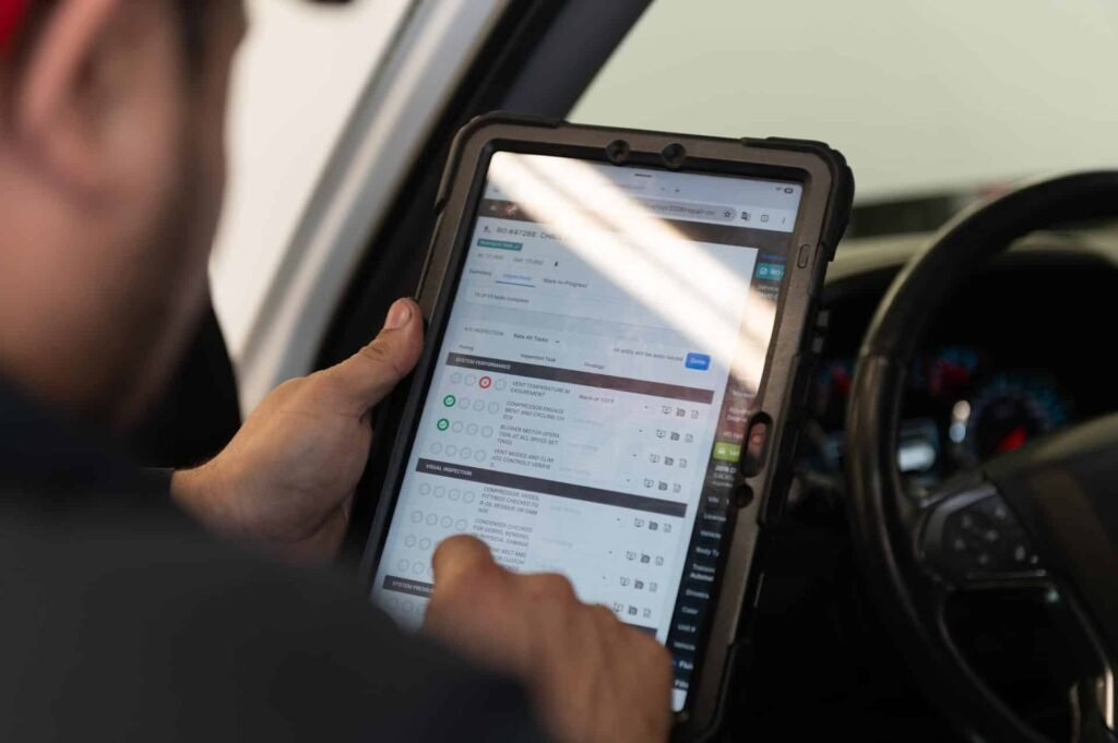 A technician completing a digital vehicle inspection on a tablet at Chuck's Auto Repair