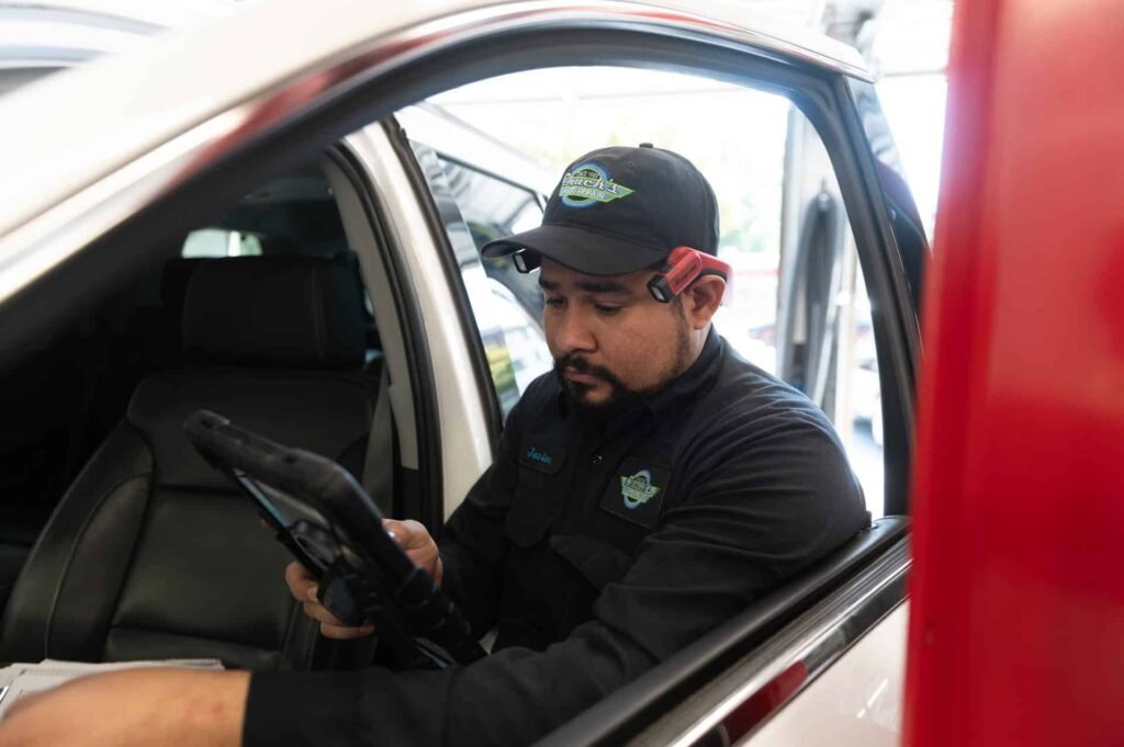 A technician running computer diagnostics with a scan tool at Chuck's Auto Repair