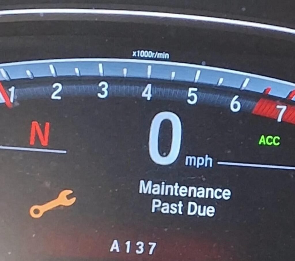 Honda dashboard displaying Maintenance Minder code A137 and a maintenance-past-due message.