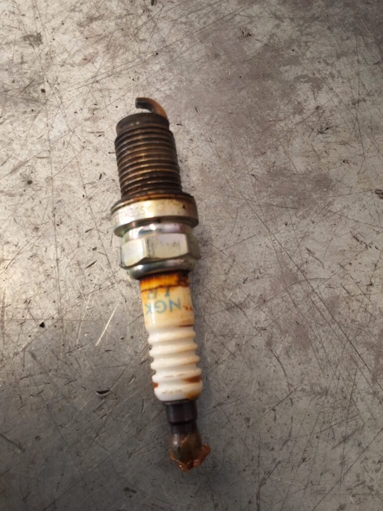 Honda CR-V Spark Plug Maintenance Used spark plug removed from a Honda CR-V during maintenance.