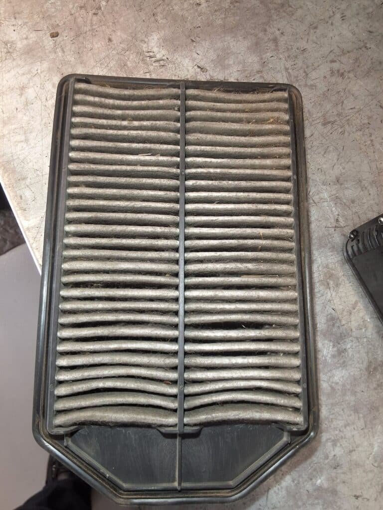 Dirty Honda CR-V engine air filter showing accumulated dirt and debris in the filter pleats.