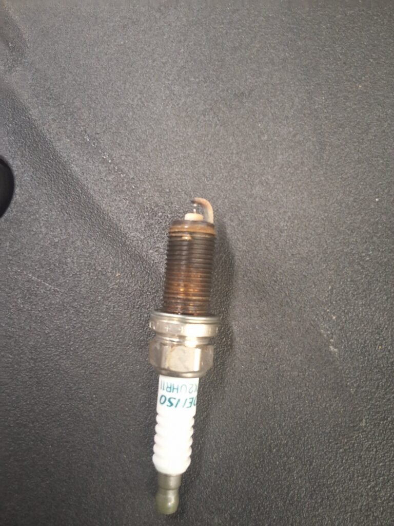 Spark plug removed for inspection from a 2015 Lexus RX450h during maintenance service.